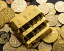 Goldbarren auf Münzen, die eine Gold-Steueroase und den verborgenen Vermögensvorteil von steuerfreiem Gold illustrieren