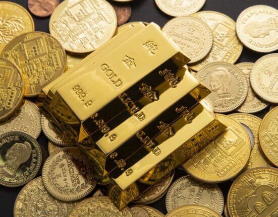 Goldbarren auf Münzen, die eine Gold-Steueroase und den verborgenen Vermögensvorteil von steuerfreiem Gold illustrieren