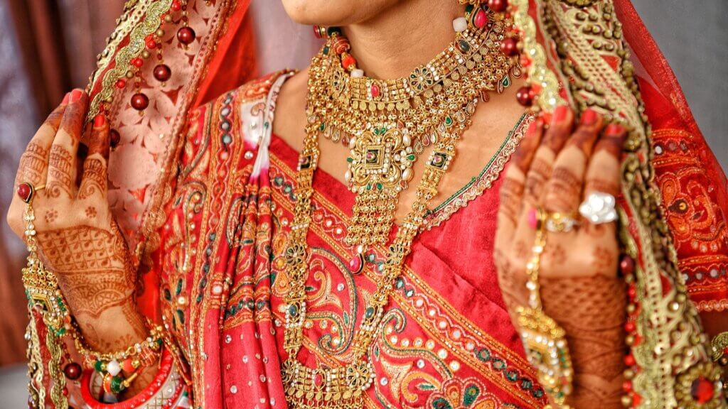 Indian bride wearing traditional gold jewelry during wedding ceremony, symbolizing India’s deep cultural and financial demand for gold
